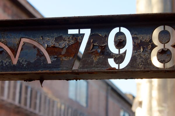 A rusted metal sign with the numbers 798 and a crescent moon.