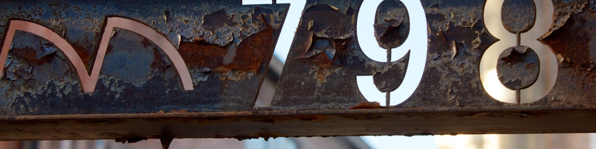 Un cartel de metal oxidado con los números 798 y una luna creciente.