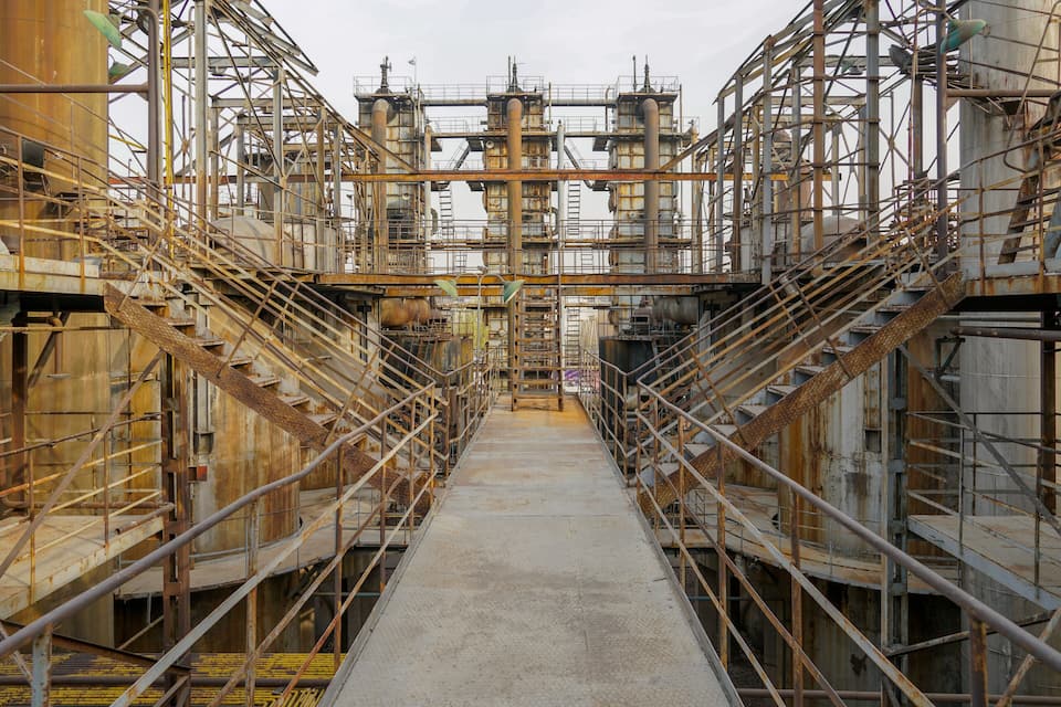 A large industrial complex with multiple levels of metal scaffolding and staircases.