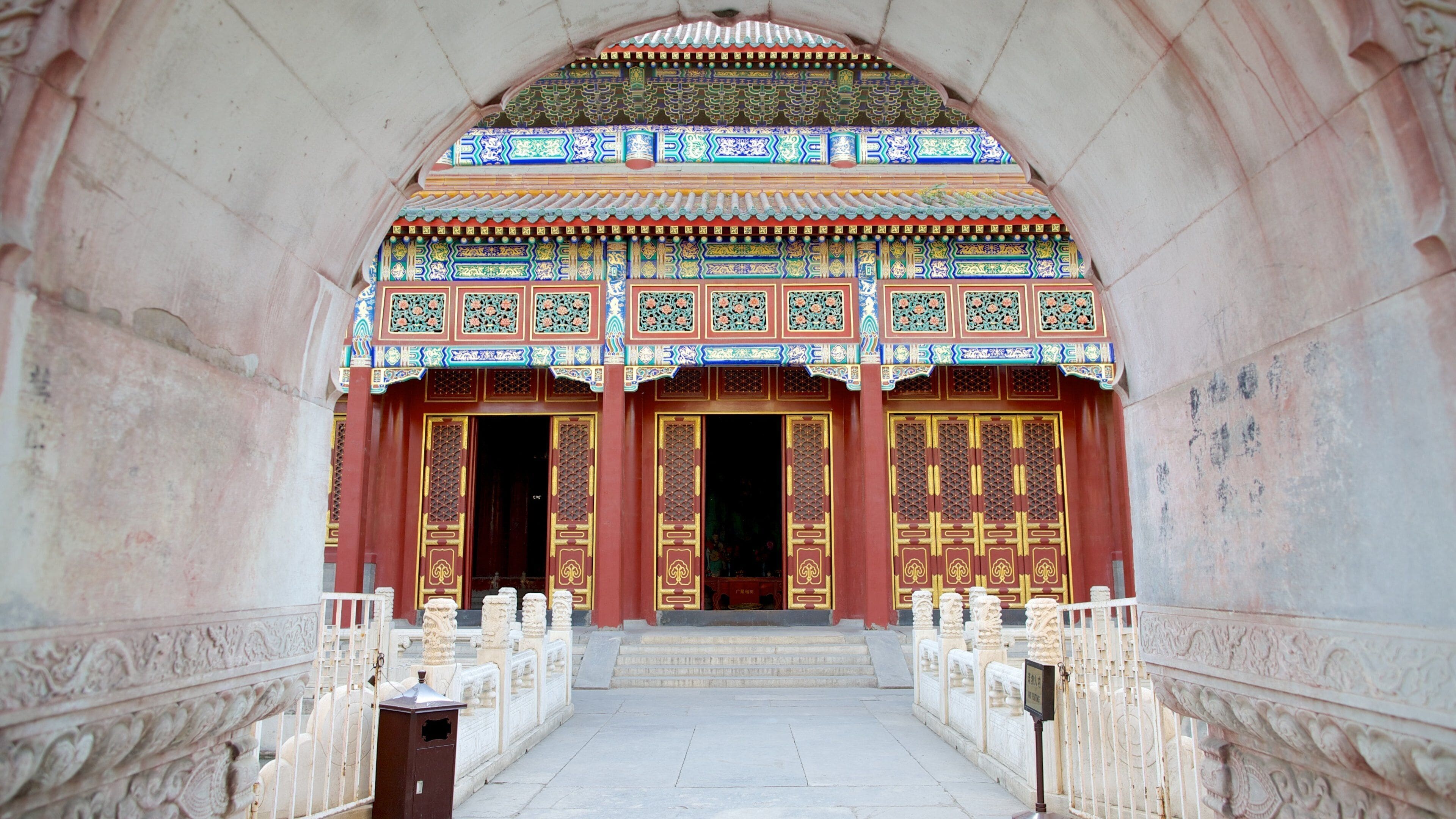 An ornate entrance with intricate tile work and golden doors.