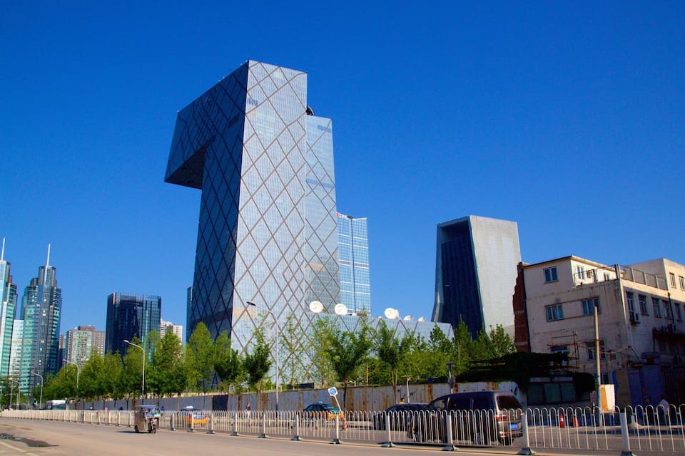 A cityscape with modern skyscrapers, including a distinctive diamond-patterned building.