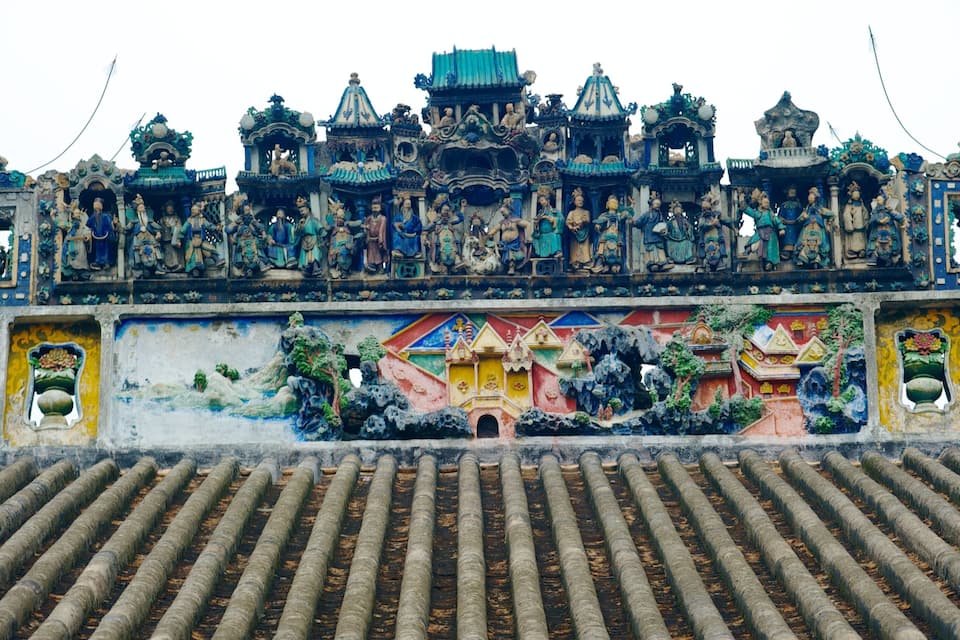 Un temple traditionnel orné de sculptures et abritant une fresque murale.