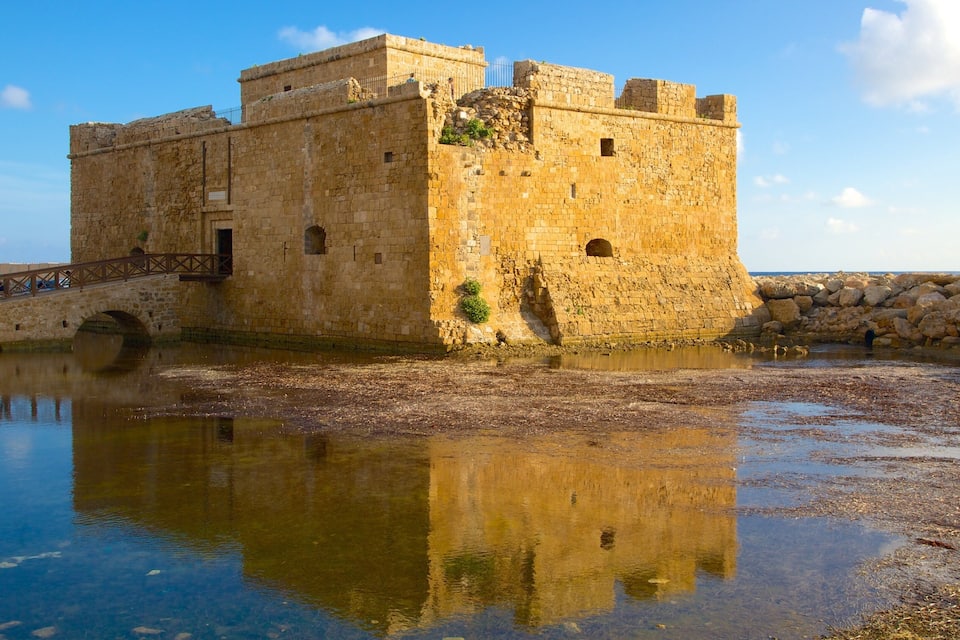 A historic stone castle with a moat and a bridge.
