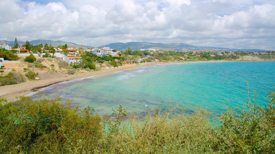 A coastal landscape with turquoise waters, sandy beaches, and residential buildings.