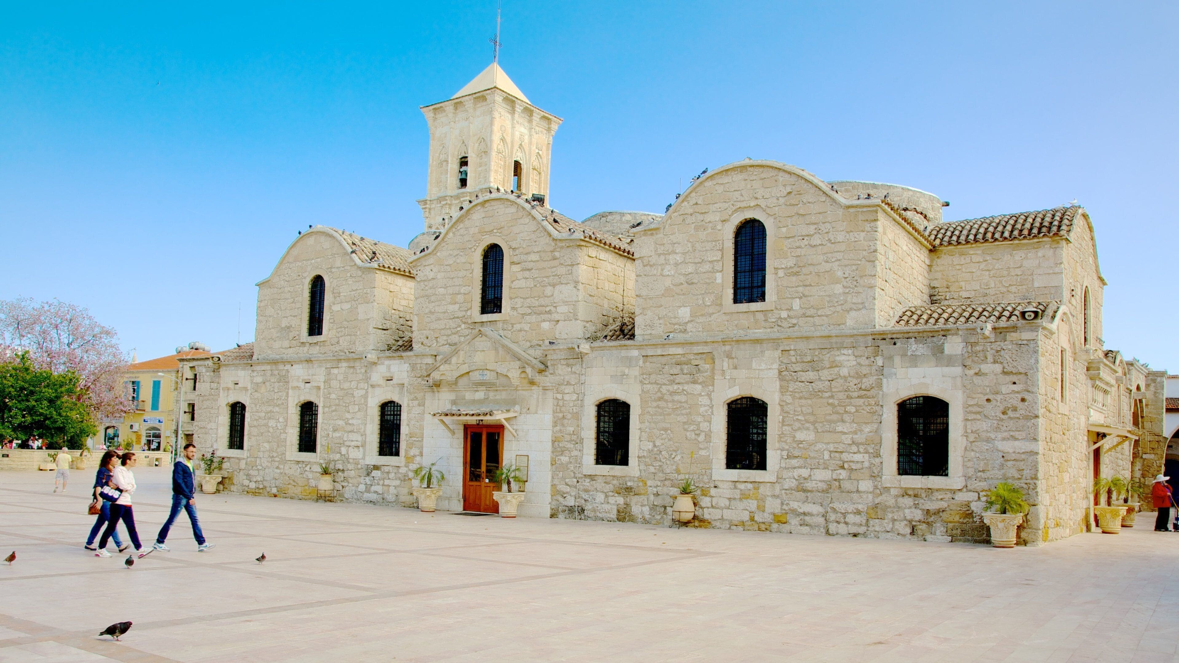 A historic stone building with a bell tower and arched windows.