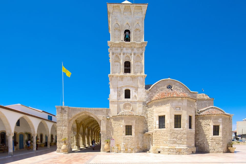 A historic church with a bell tower, arches, and a tiled roof.