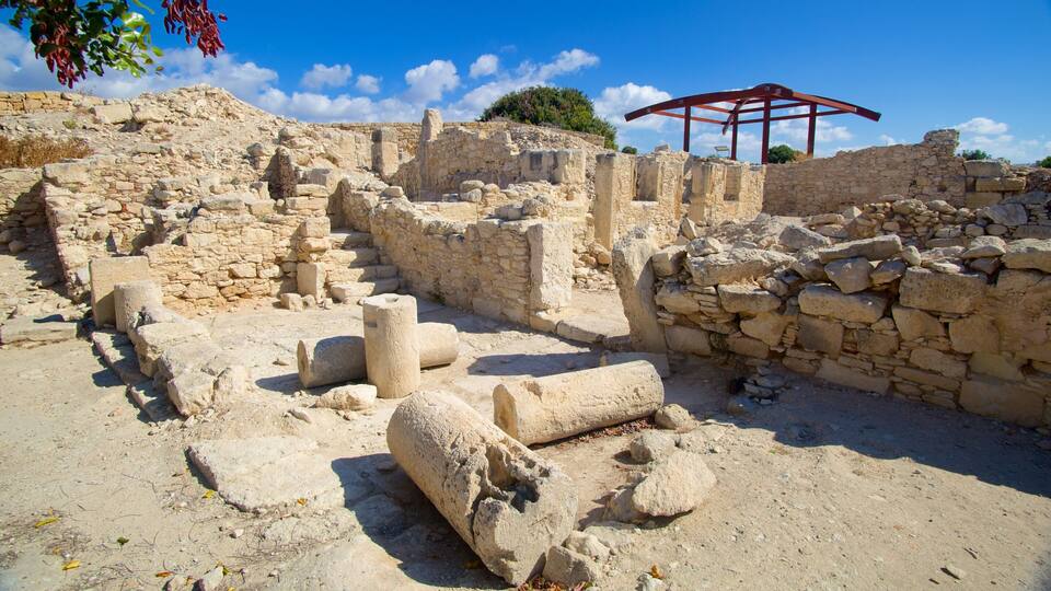 Ancient stone ruins with columns and a red pergola.