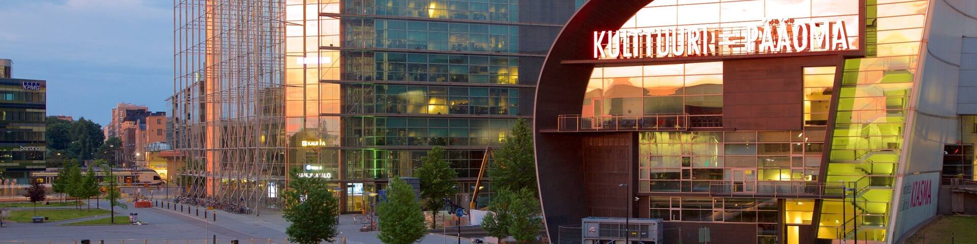 A modern building with a curved facade and a large illuminated sign.