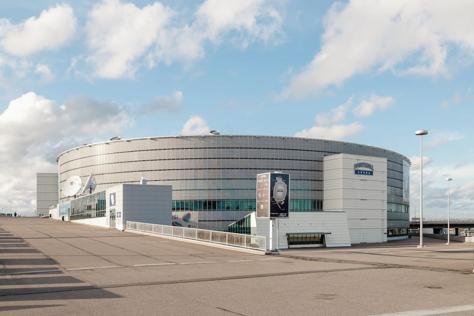 A modern stadium with a curved roof and large windows.