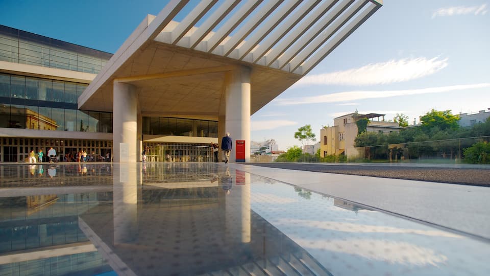 A modern building with a glass facade and a reflective floor.