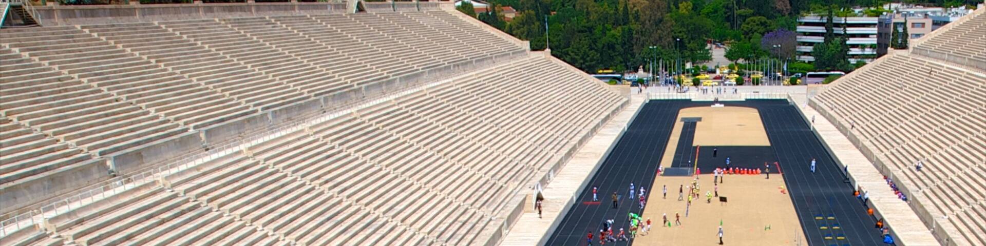 An empty stadium with tiered seating and a central track.