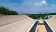 An empty stadium with tiered seating and a central track.