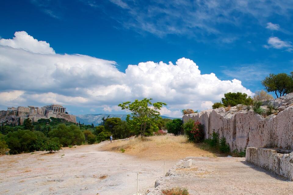 A rocky landscape with ancient ruins and a clear blue sky.