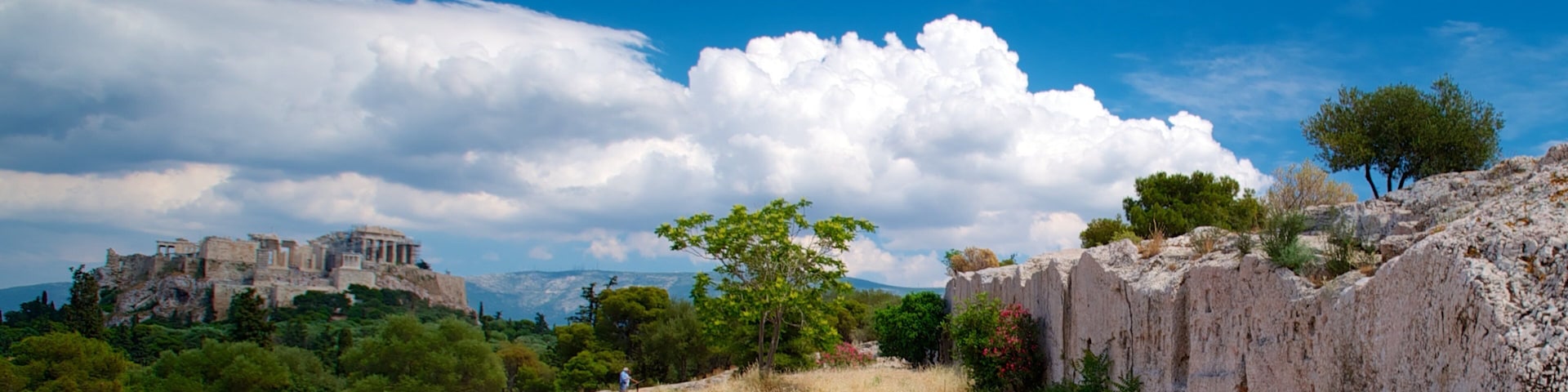 Paisaje rocoso con ruinas antiguas y un cielo azul despejado.