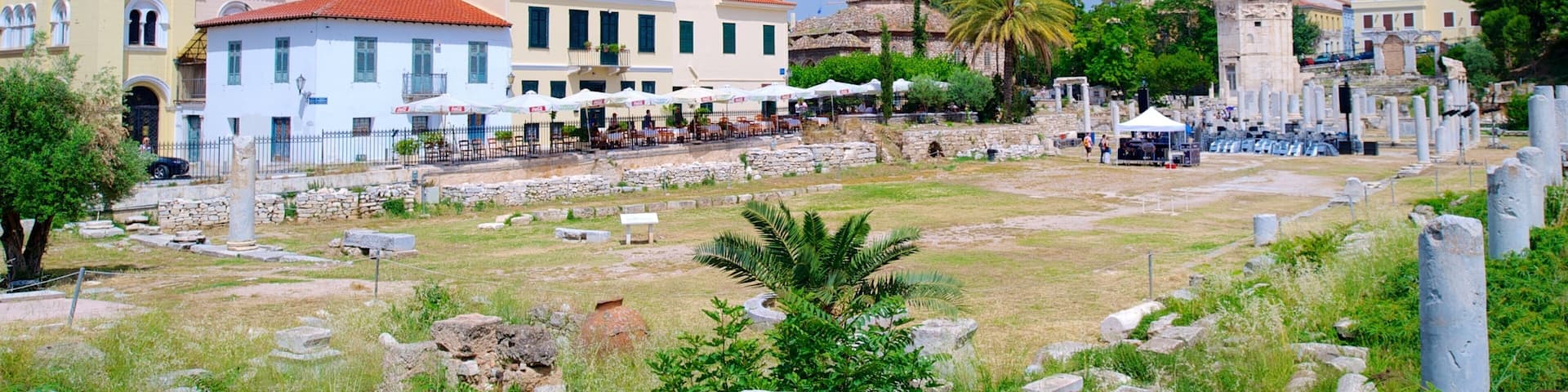 Ancient ruins with stone columns, a temple, and traditional buildings.