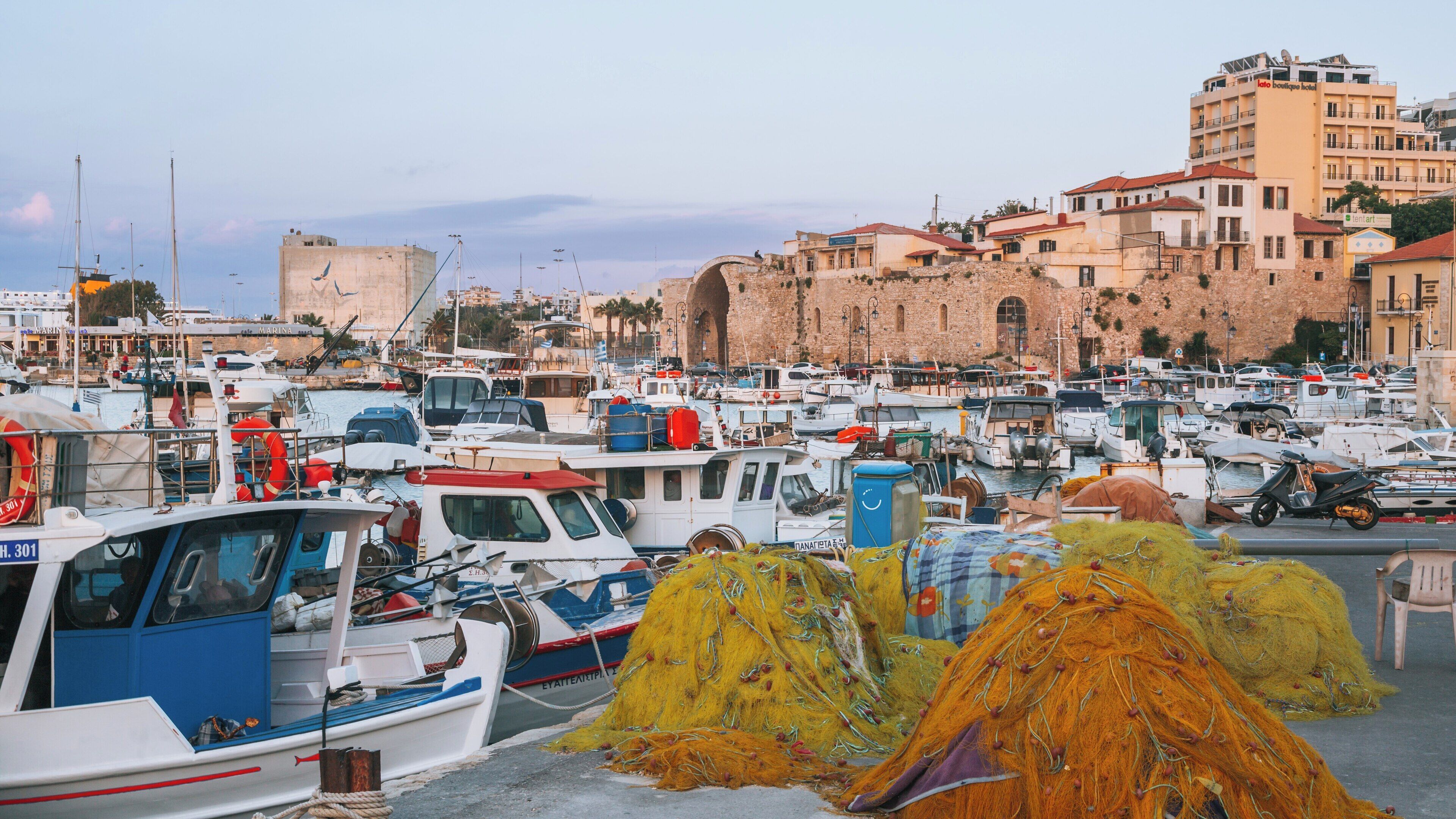 Heraklion Port bustles with fishing boats and colorful nets in the heart of Crete, Greece during a serene evening