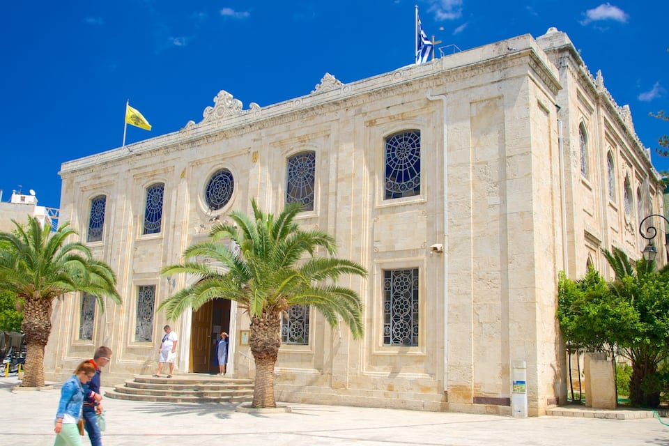 Um edifício histórico com janelas ricamente decoradas e uma bandeira.