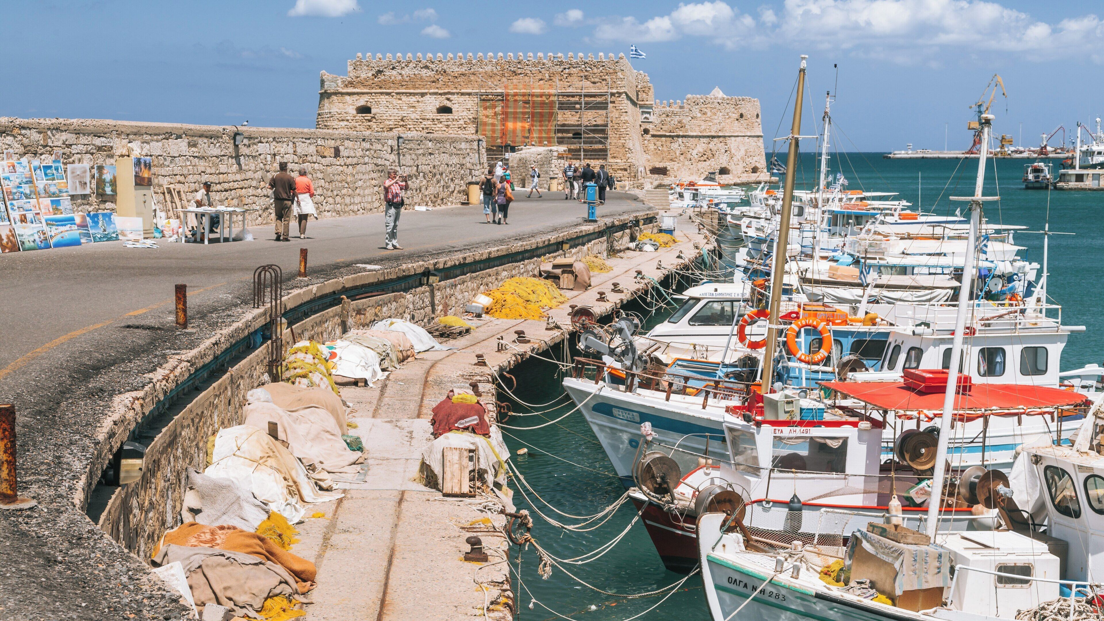 Exploring Koules Fortress in Heraklion, Crete, Greece, with charming boats and scenic views by the vibrant harbor under a clear blue sky