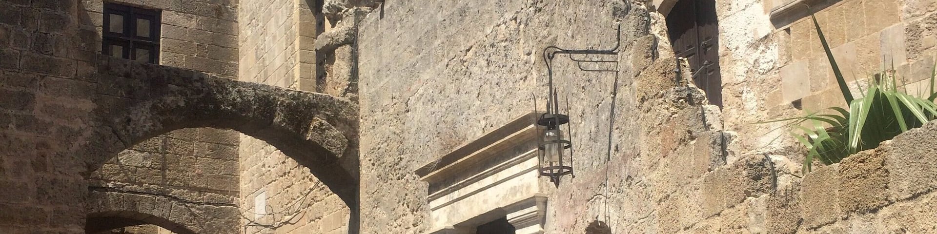 An ancient stone building with arched doorways and a cobblestone courtyard.