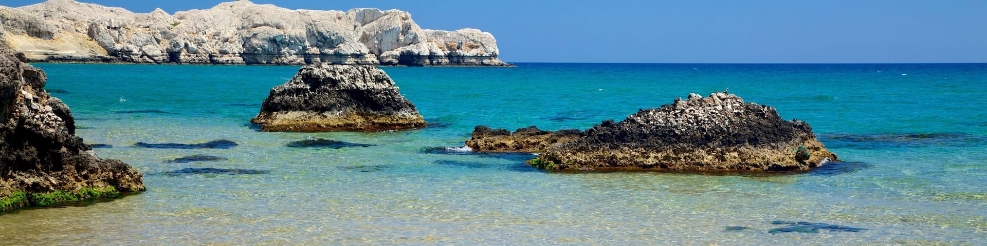 Tsambika Beach which includes landscape views, rugged coastline and a pebble beach