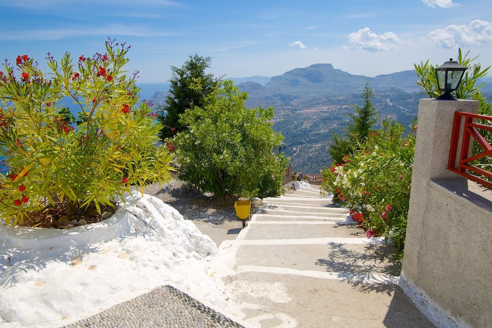 Un escalier en pierre avec des rampes rouges menant à un belvédère offrant une vue panoramique.