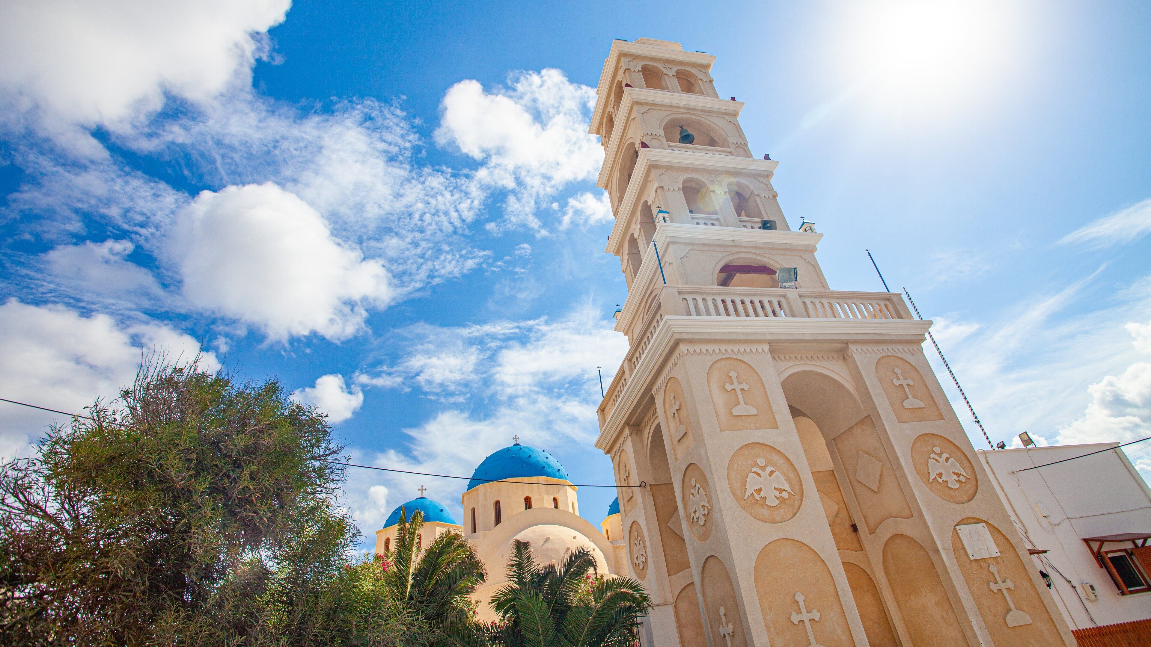 A church with a tall bell tower and blue domes.