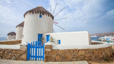 Un edificio blanco con una puerta azul y un molino.
