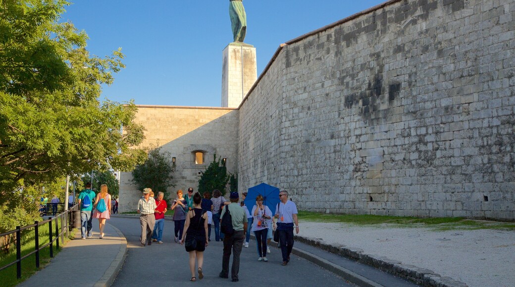 Liberty Statue showing heritage elements and a monument as well as a small group of people