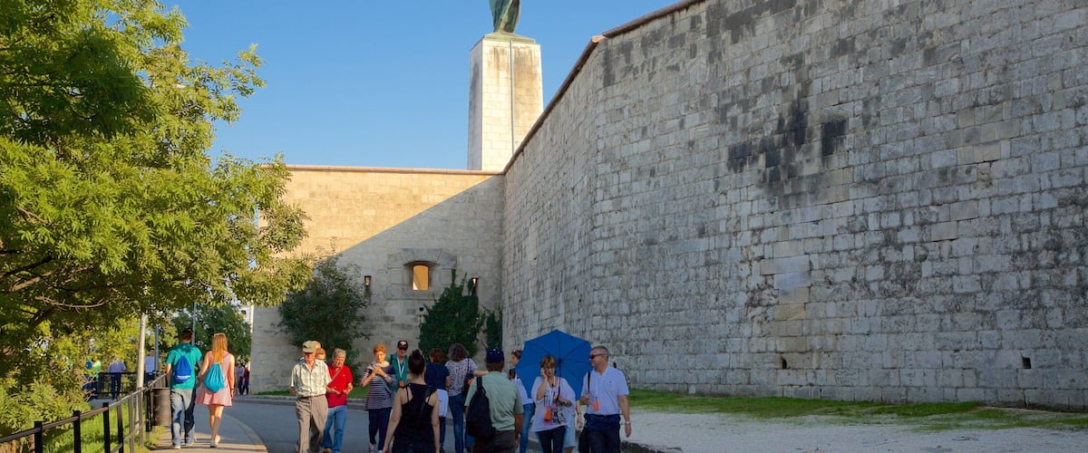 Estatua de la Libertad mostrando elementos patrimoniales y un monumento y también un grupo pequeño de personas