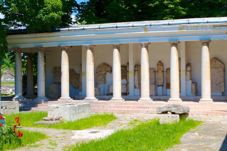 Ancient columns with a stone structure in a garden.