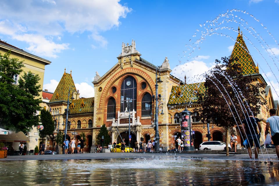A historic building with ornate architecture and a fountain in front.
