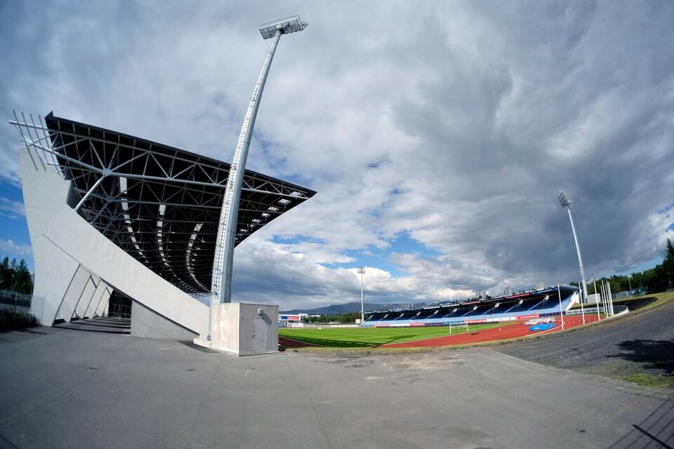 Een stadion met een modern ontwerp, een atletiekbaan en een groot open veld.
