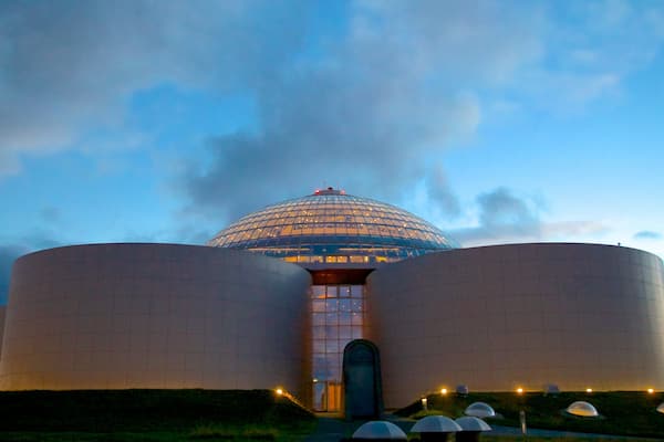 A large, modern building with a dome and two cylindrical structures.
