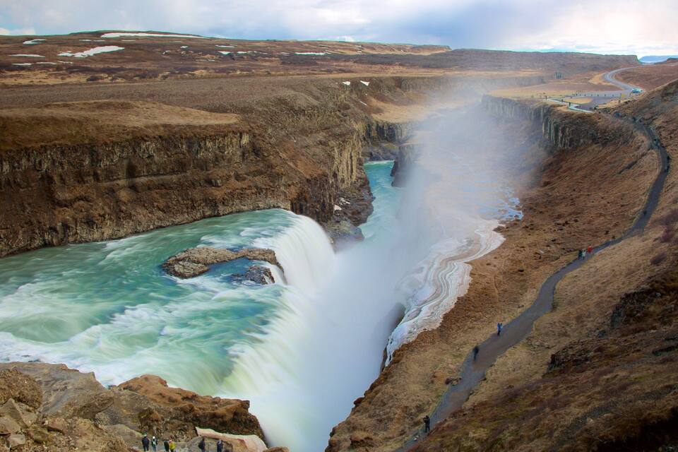 Una cascada que se precipita en un río rodeado de un paisaje árido.
