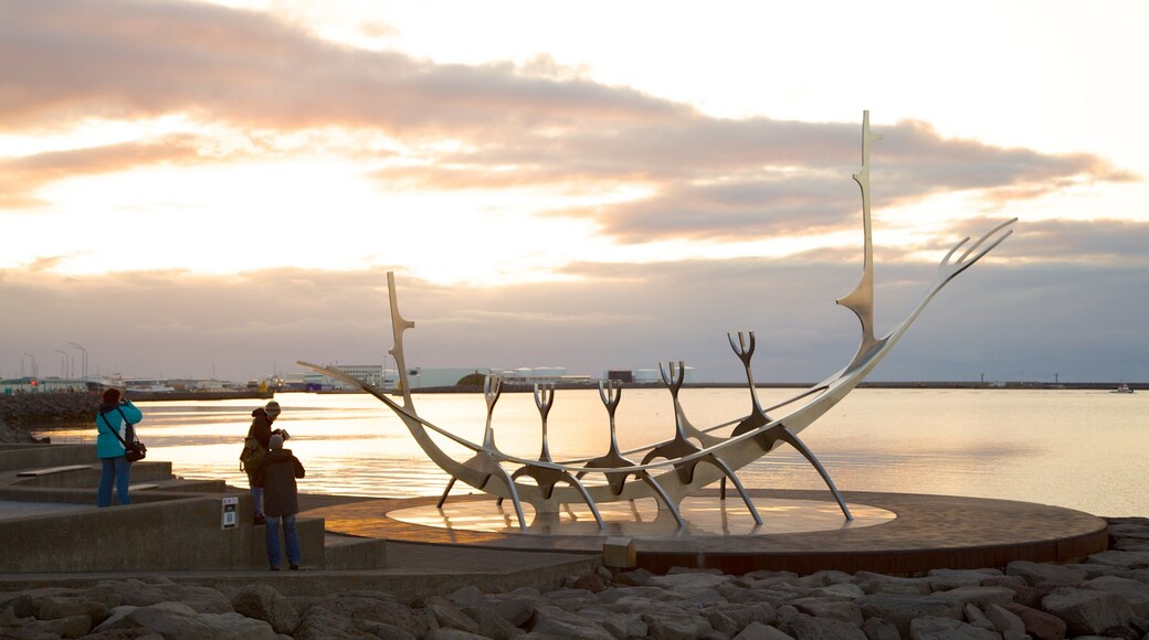 Reykjavík havn fasiliteter samt kyst, utendørs kunst og solnedgang