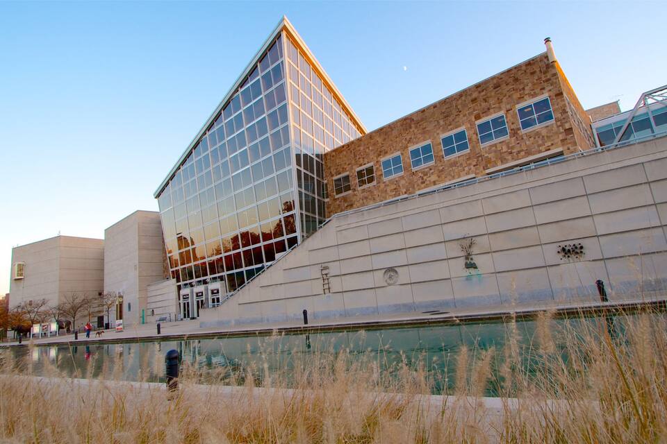 A modern building with a glass facade and a brick structure.