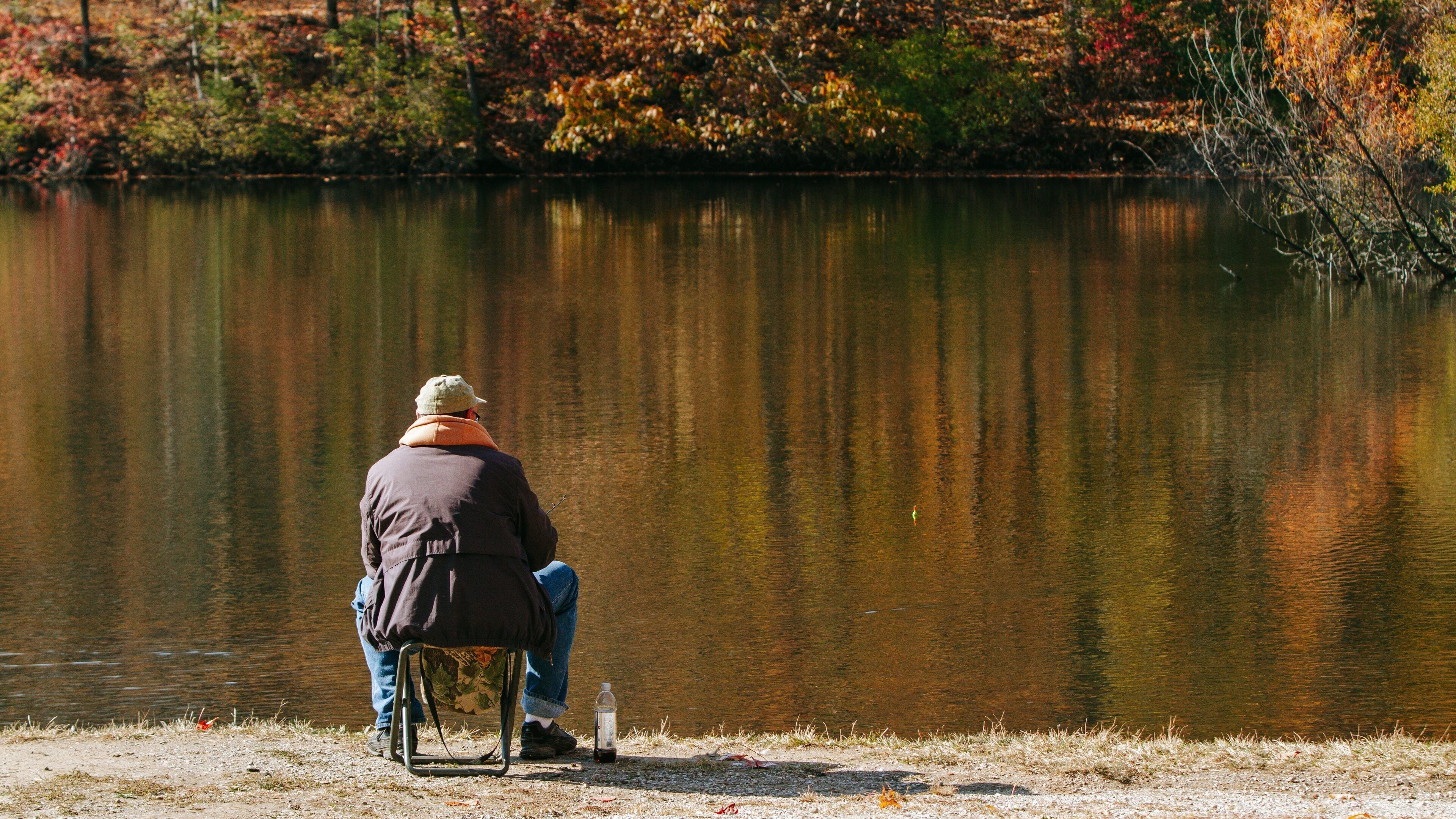 Eagle Creek Park featuring a lake or waterhole and fishing as well as an individual male