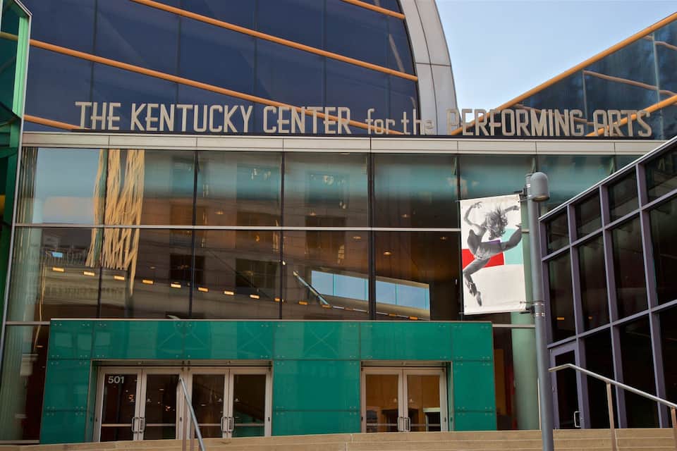 La façade du bâtiment du Kentucky Center for the Performing Arts, avec ses grandes fenêtres en verre et son panneau indicateur bien visible.
