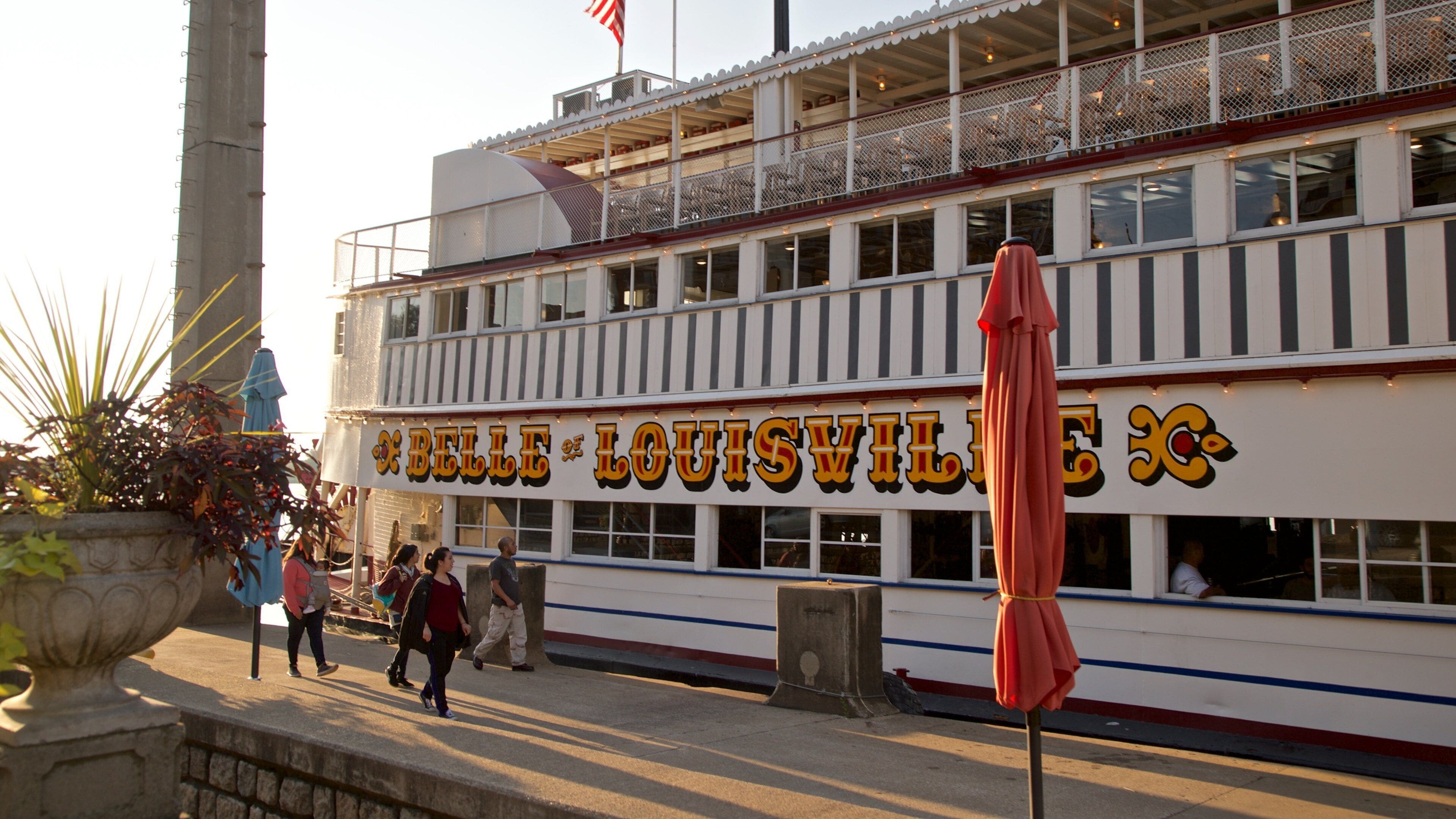 Belle of Louisville ofreciendo señalización y un ferry y también un pequeño grupo de personas