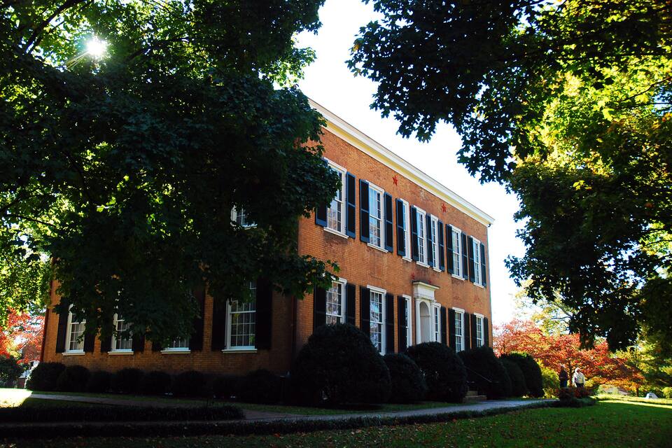 A brick building with large windows and a well-maintained lawn.