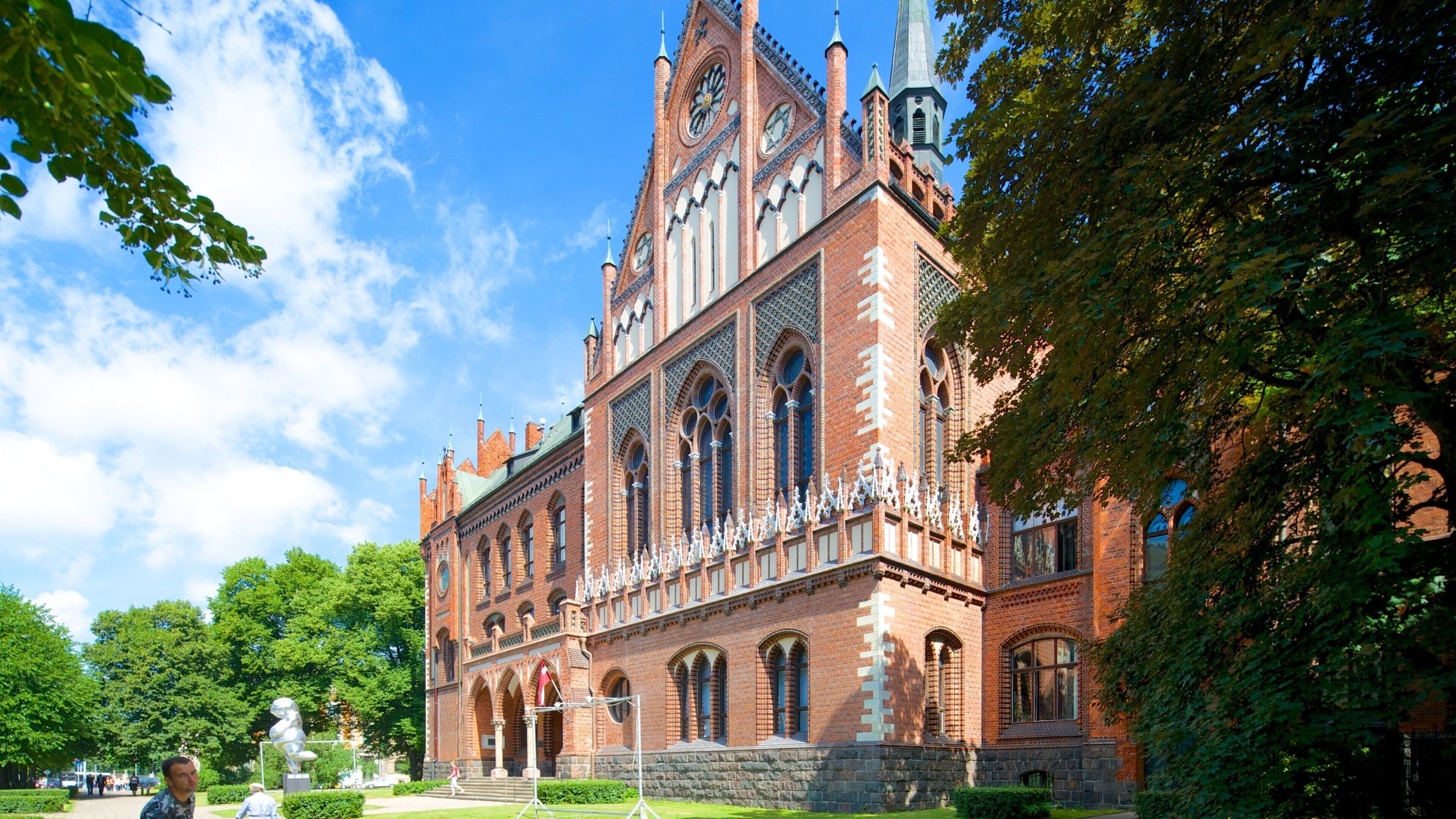 A historic building with intricate architecture, large arched windows, and a prominent clock tower.