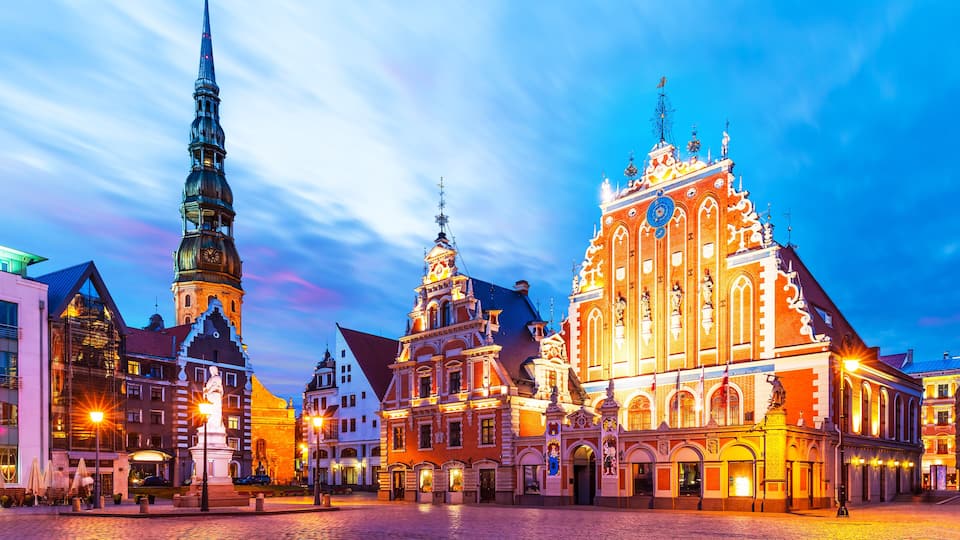 Een historisch Europees plein met een opvallende kerk, een hoge kerktoren en traditionele gebouwen.