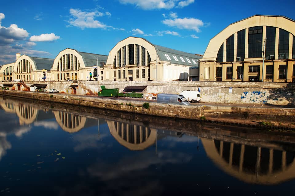 A historic building with arched windows and a reflection in the water.