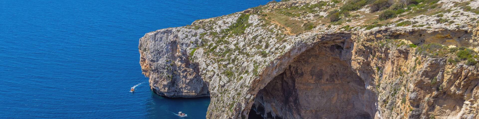 Blue Grotto rock cliff arch in Malta, aerial view from the Mediterranean Sea to the island.