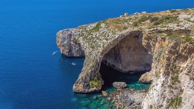 Blue Grotto rock cliff arch in Malta, aerial view from the Mediterranean Sea to the island.
