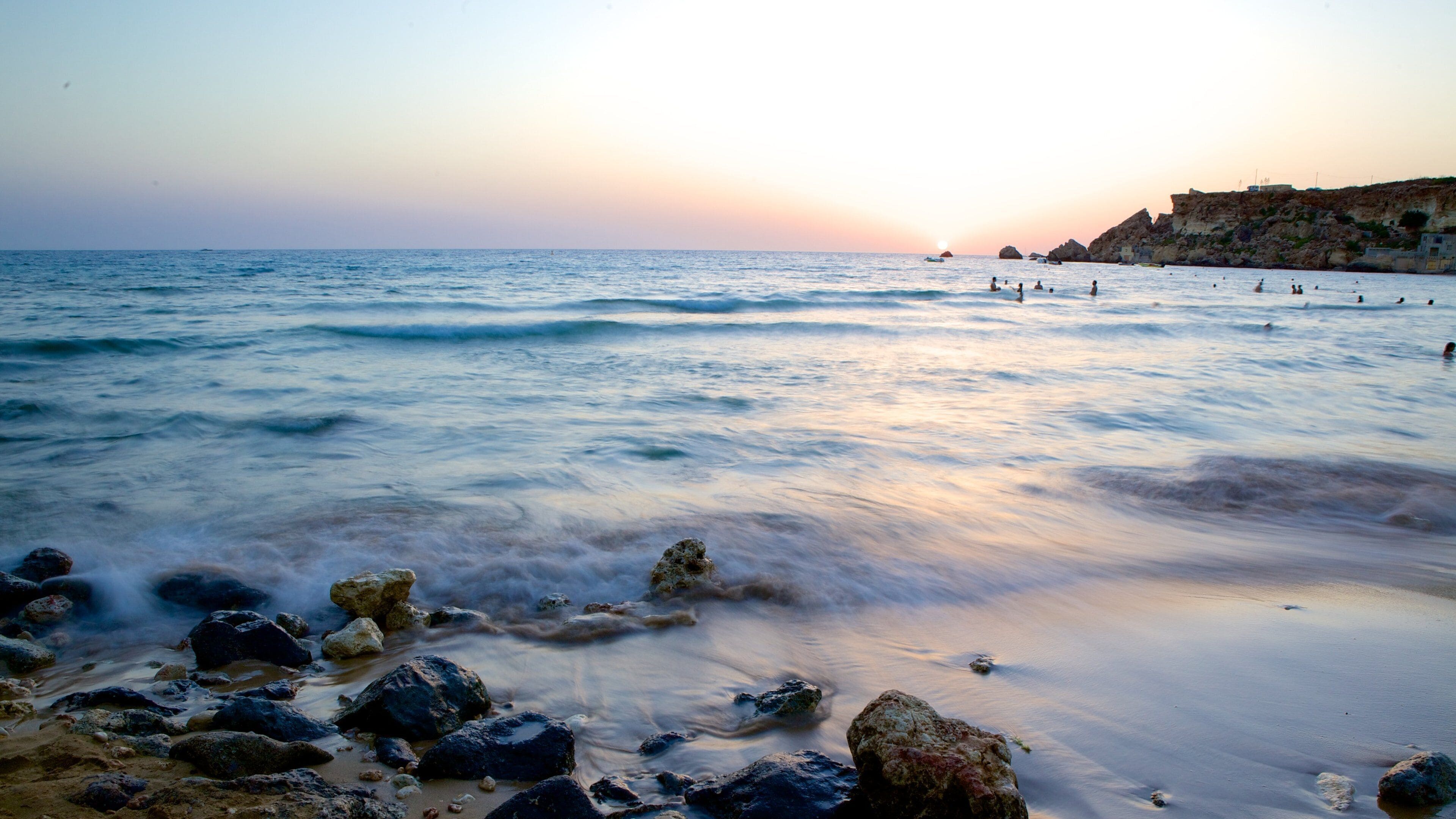 Golden Sands Beach featuring a sunset and rugged coastline