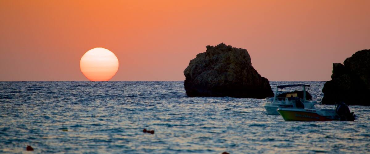 Golden Sands Beach featuring rocky coastline and a sunset