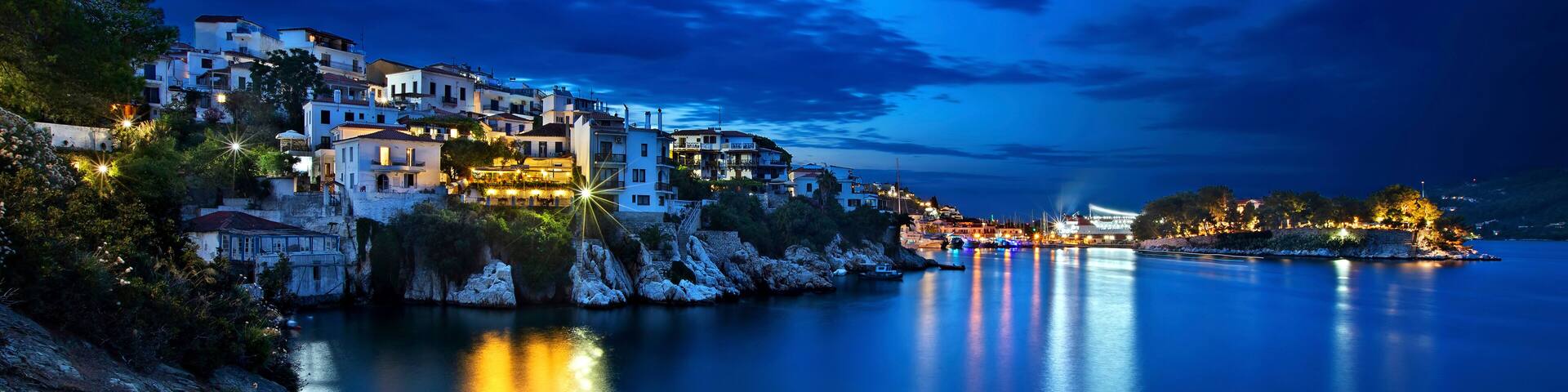 Night view of Plakes, the oldest neighborhood of Skiathos town. To the right, you can see Bourtzi castle. Skiathos island, Northern Sporades, Greece.