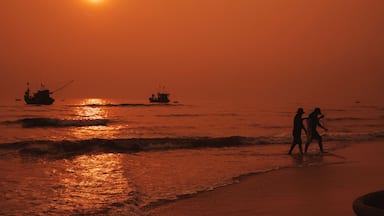 Silhouettes of Vietnamese fishermen on the beach by sea with fishing boats in a fishing village in morning at sunrise in Vietnam