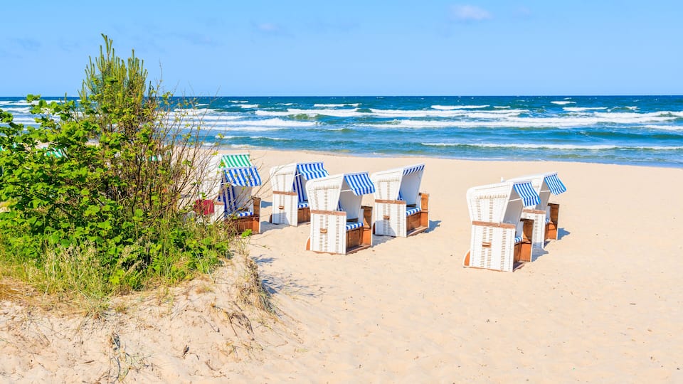 Traditional wicker chairs on sandy beach in Baabe town, Ruegen island, Baltic Sea, Germany